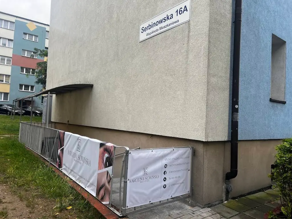 Wejście do Karolina Sowińska Beauty Studio przy Serbinowskiej 16a w Kaliszu, oznaczone banerami salonu.